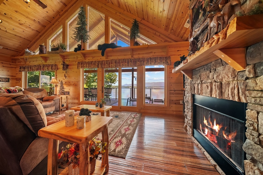 Warm cabin interior with fireplace and lake-facing windows